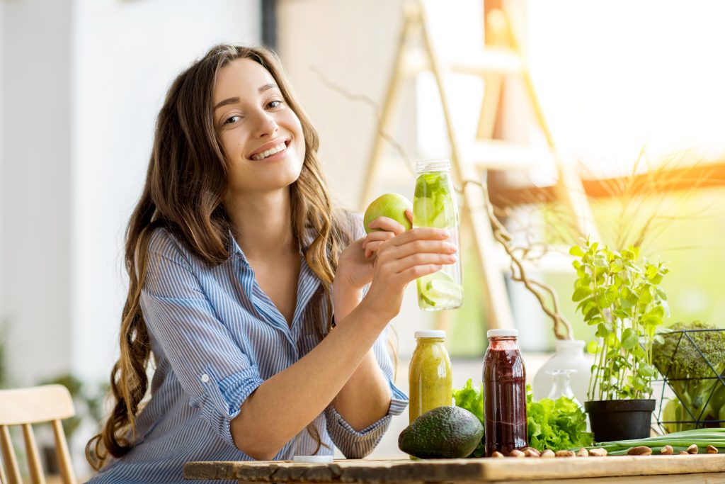 Woman with green healthy food and drinks at home